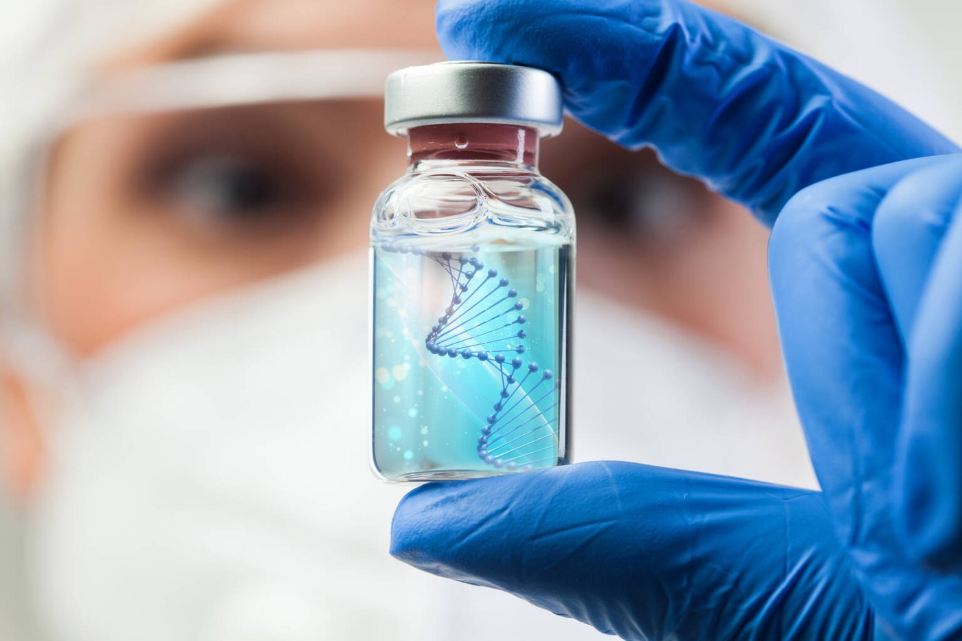 Gloved hand holding a vial containing a DNA helix