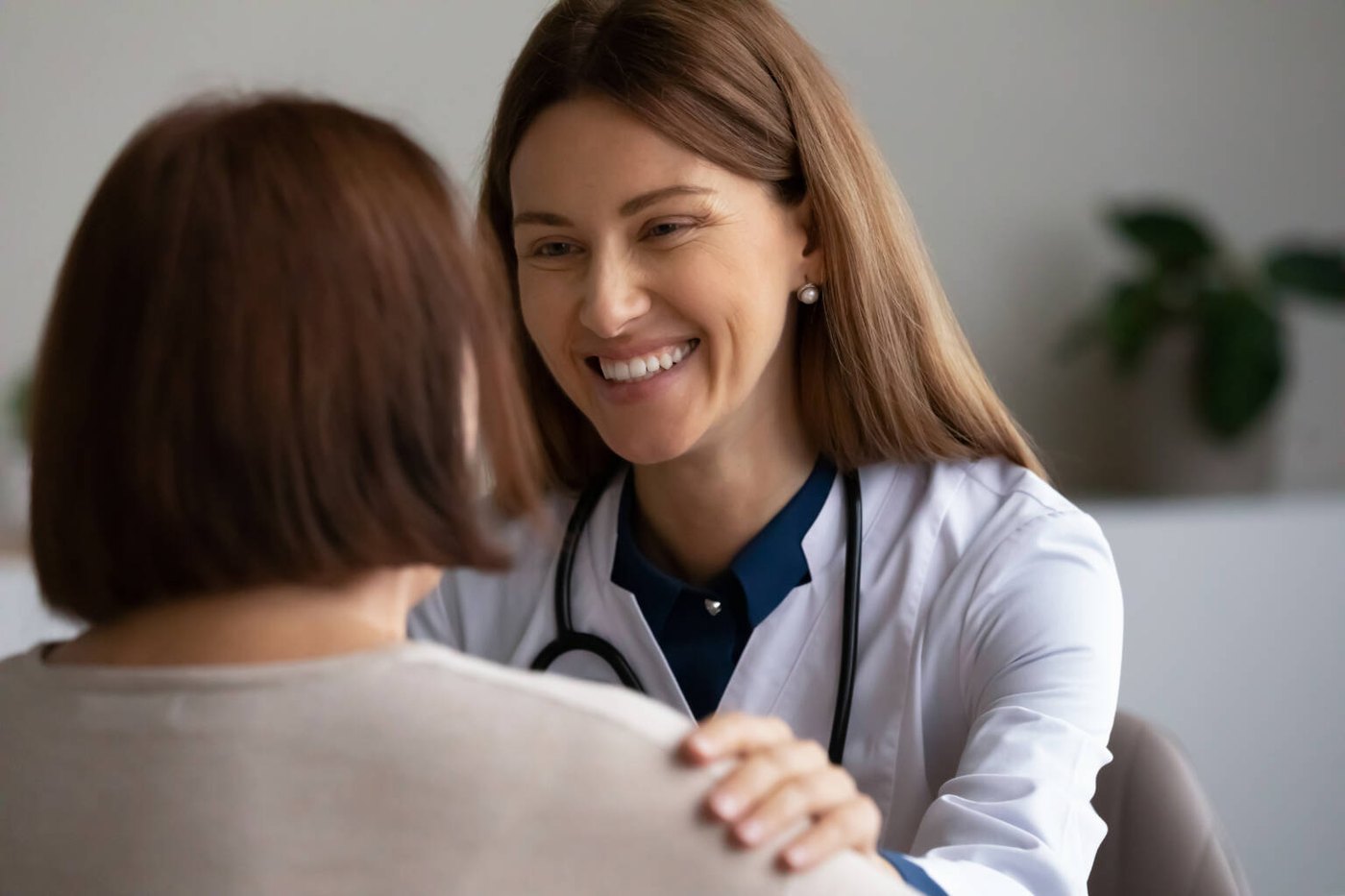 A smiling doctor reassuring a patient during a private consultation