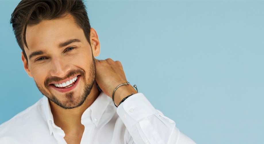 Smiling man in a white shirt against a soft blue background